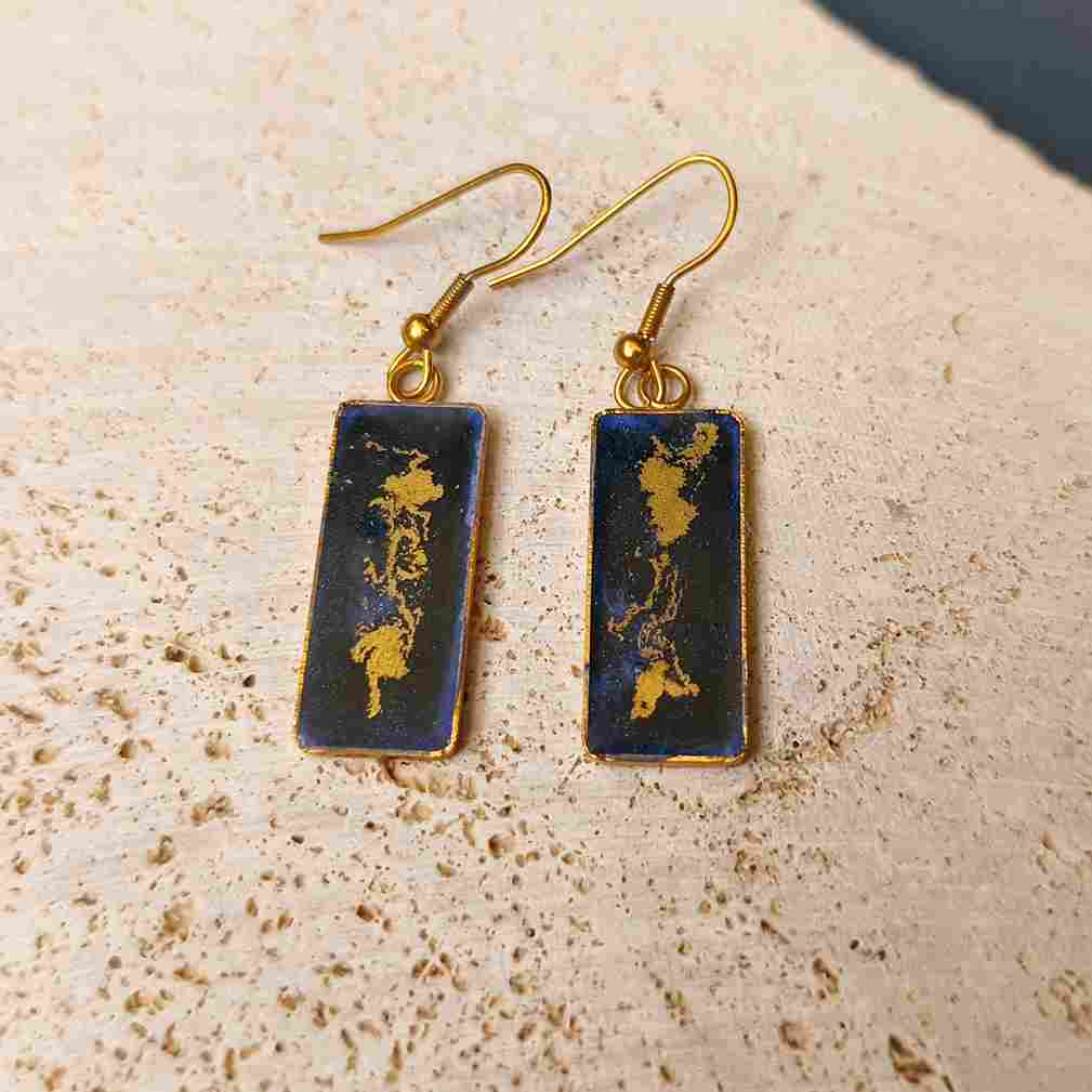 Bijou artisanal bleu nuit avec motifs dorés ondulants