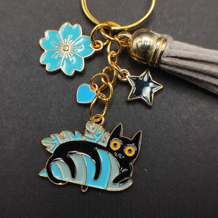 Porte-clé chat noir avec feuille et fleur de sakura bleue, pompon bleu