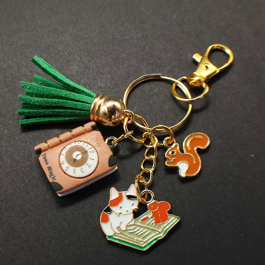 Fiche produit porte clé Chat tricolore en métal émaillé avec écureuils et livres